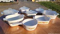 Eight CorningWare dishes grouped on outdoor table