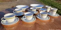 Full set laid out showing cups, saucers and bowls