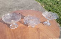 Group shot of three pressed glass pedestal dishes