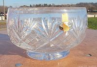 Side view of clear cut crystal bowl on pedestal base showing diamond and fan pattern and original label