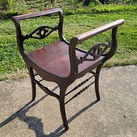 Full view of mahogany saddle chair outdoors