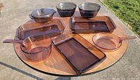 All nine amber glass cookware pieces arranged on table