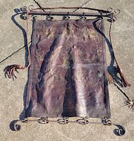 Full view of leather tapestry with iron rods and hanging cord