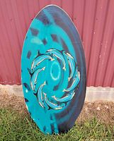 Front of board showing turquoise paint, black swirl, dolphin ring graphic
