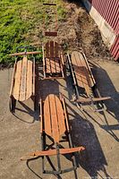 All four wooden sleds laid out on concrete
