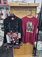 Both sweaters hanging on rack for overall view