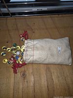 Cloth pouch filled with assorted marbles on wooden surface