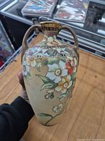 Side view of hand-painted Nippon vase showing floral motif and twin handles