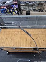 Full view of wooden longbow on table showing overall form and string attached