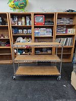 Front view of chrome wire rack with three plywood shelves on casters