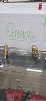 Two metal ox figurines and glass ship bottle on glass shelf