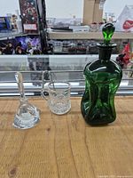 All three items: green decanter, clear perfume bottle base and stopper, clear cup