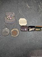 Three vintage beaded purses and four eyeglass cases arranged on floor