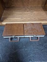 Both closed brown cassette cases side by side showing exterior and handles