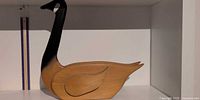 Left profile of carved wooden Canada goose on shelf
