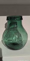 Front view of deep green hand-blown glass vessel showing bulbous shape and color