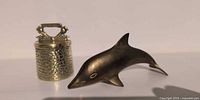 Dolphin figurine and bell side by side