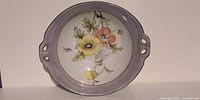Top view of Noritake porcelain handled bowl showing floral design, lavender rim and pierced handles