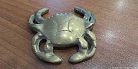 Top view of brass crab figurine showing carapace and claws