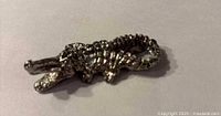Top view of silver-tone metal alligator figurine showing detailed scales and overall shape