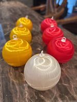 Group of seven satin-wrapped ornaments on marble surface