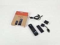 Complete set laid out: stick, remote, USB cable, power adapter, box