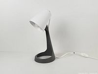 Front angled view of Ikea Svallet lamp showing white ribbed shade and grey base