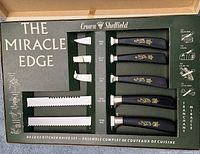 Display box open showing five handled knives and packaging graphics