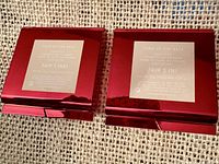 Back view of two closed red compacts showing shade labels Fair 1 (NR) and Fair 3 (N)