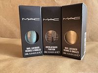 Front view of three boxed MAC bottles