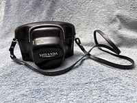 Closed leather case with Miranda logo and strap