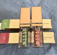 Both sealed eye shadow tubes standing in front of their boxes