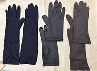 Four gloves shown: both sides of black opera-length pair plus one glove each of two wrist-length pairs