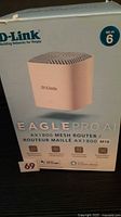 Front of sealed D-Link Eagle Pro AI AX1800 mesh router box