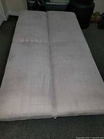 Futon fully folded flat into bed position showing full cushion