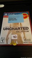 Front view of sealed PS4 Uncharted: The Nathan Drake Collection game with price sticker