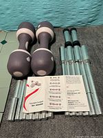 Overall view showing both dumbbell shells, all weight bars and instruction leaflet