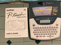 Brother P-touch label maker with user guide shown together