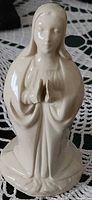 Front view of off-white glazed Virgin Mary figurine showing praying hands and robe detail