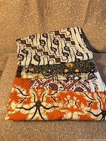 Stack of folded batik fabrics showing four visible patterns