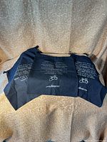 Three black John Fluevog shoe bags displayed