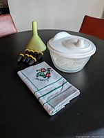 salad spinner, corn holders, juicer, tea towel displayed on table