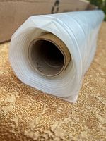 Close-up of film roll end showing translucent plastic and cardboard core