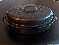 Lidded black speckled oval enamel roasting pan, side view