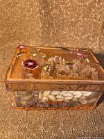 Clear plastic box with embedded shells and flowers