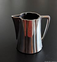 Front view of silver-plate jug showing handle and spout