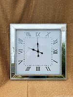 Front view of square clock showing mirrored frame and dial