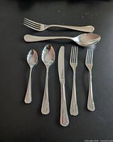 Group of utensils showing fork, spoons, knife illustrating pattern and finish