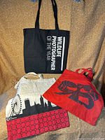 All three tote bags laid out showing full designs