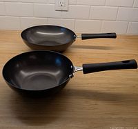 Two nonstick sauté pans side by side showing size difference and handles